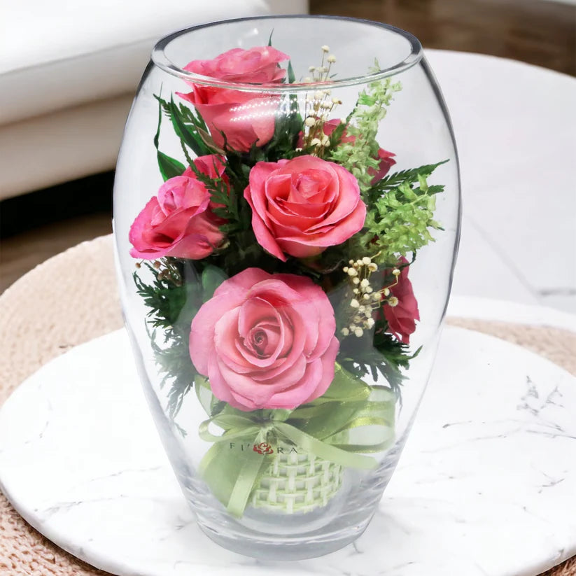 Seven Vibrant Rosy Charm Pink Roses in a Stylish Round Glass Vase